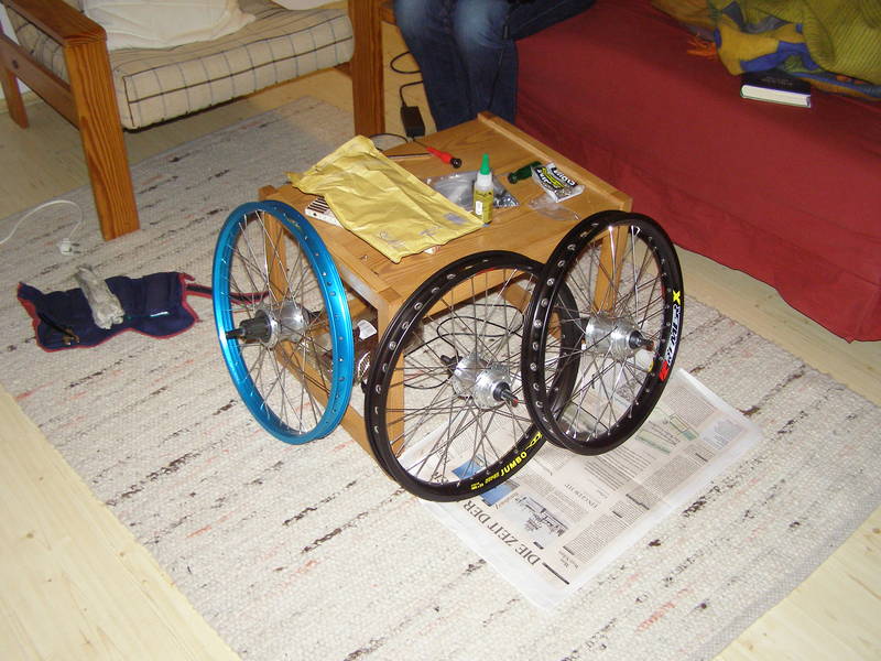 Eingespeichte Laufräder für unser Tandem, daneben mit blauer Felge das Hinterrad des Schwesterprojekts.
