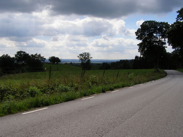 Straße, Wiese, Himmel mit Wolken