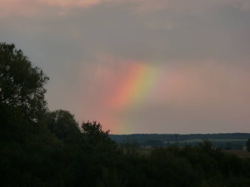 Wolken spielen Prisma und teilen das Licht in die Regenbogenfarben auf