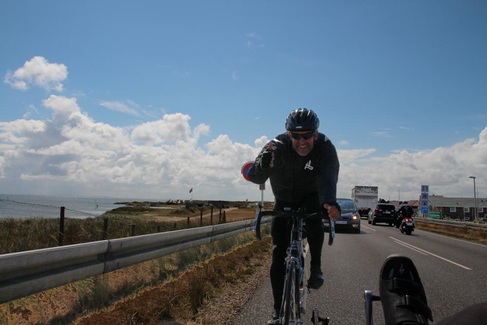 Ein Schweizer Rennradfahrer fährt einige Kilometer in unserem Windschatten und zeigt uns bei 30km/h Daumen hoch.
