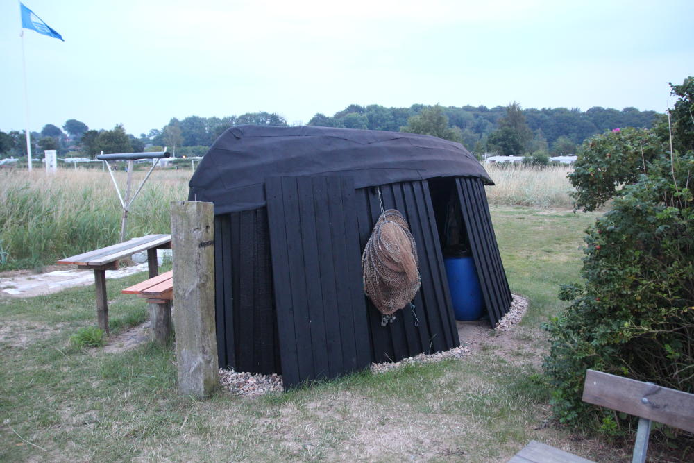 Eine Fischerhütte am Strand aus dem, was Fischer eben so haben.
