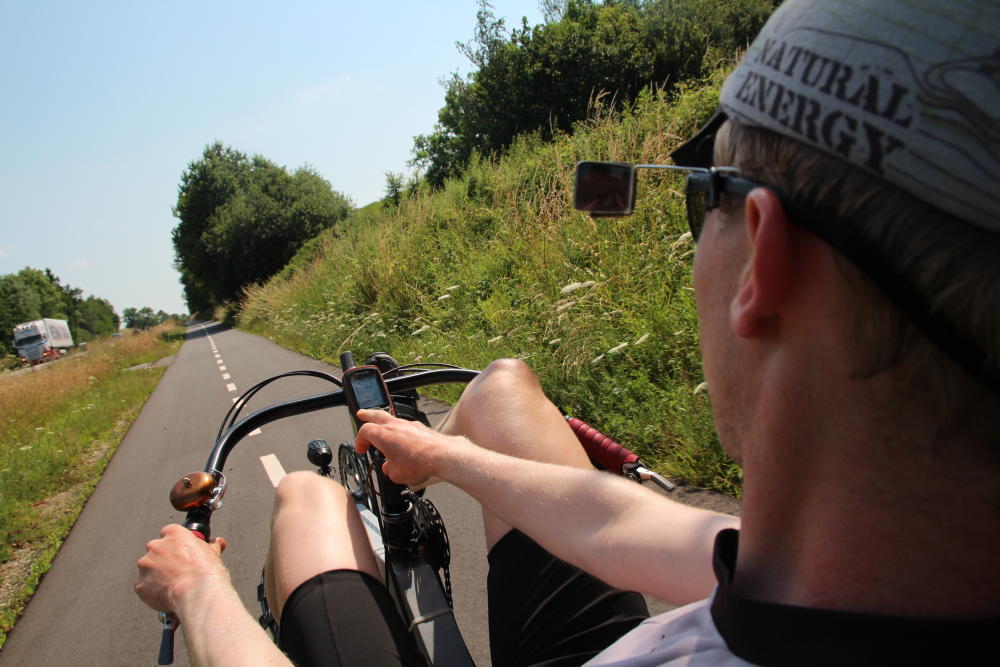 Martin am Spielen am GPS, was durchaus nicht ganz einfach ist: Man darf mit dem rechten Knie nämlich weder an den Lenker, noch an den Arm stoßen, weil dies die Fahrtrichtung unvorteilhaft beeinflussen kann.
